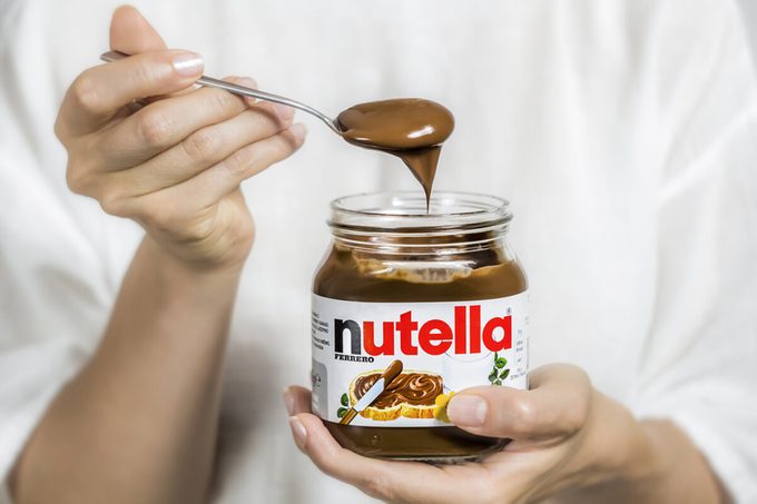 Jar of Nutella. Spoon in chocolate cream, dessert.