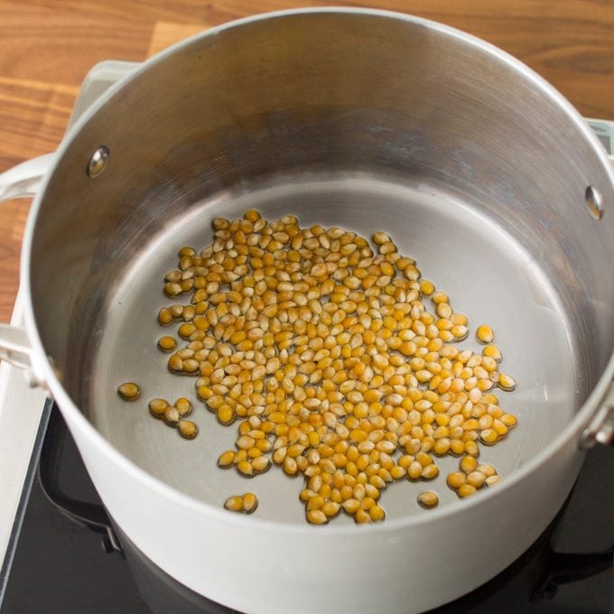 A large, heavy-bottomed pot with popcorn kernels and oil in the bottom—the first step for homemade stovetop pocorn.