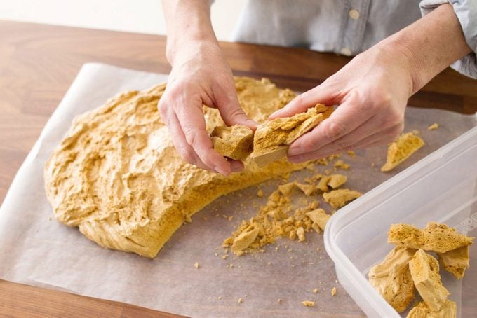 hands breaking sponge candy into pieces