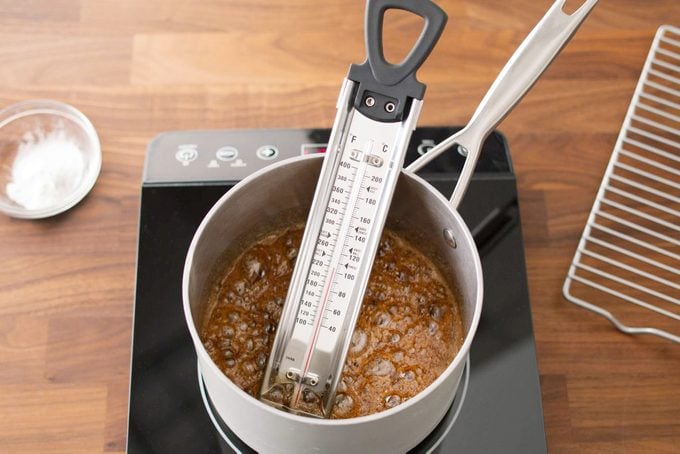 thermometer in a pot on the stove while making sponge candy