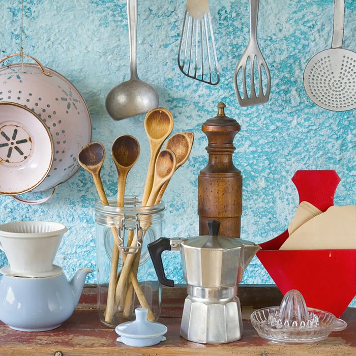 various vintage kitchen utensils,against blue wall