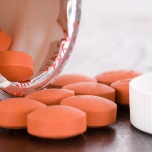 Over the counter medication on black table with bottle and cap