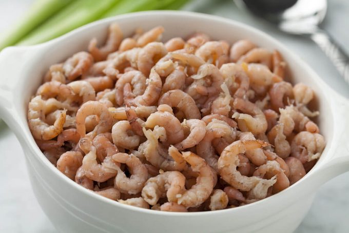 Bowl with peeled brown shrimps close up