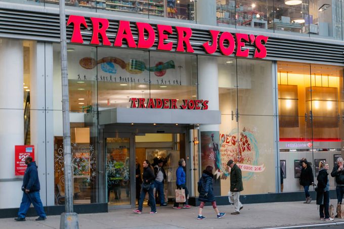 People walk by a Trader Joe's grocery store