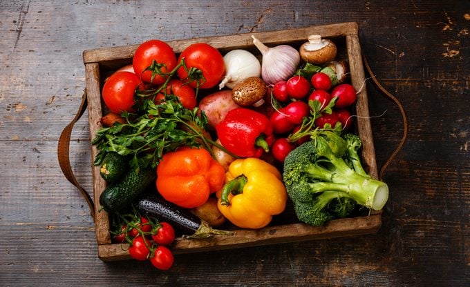 Fresh vegetables in wooden box on wooden background;