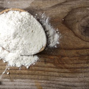 Organic wheat flour in wooden spoon
