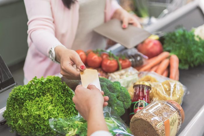 Customer giving card to supermarket worker