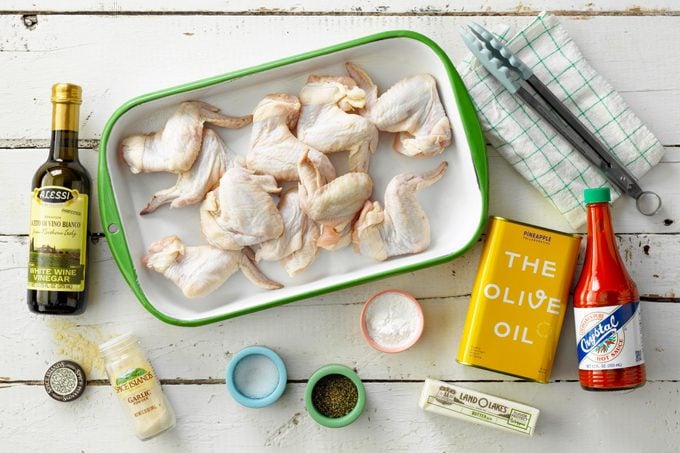 Grilled Chicken Wings ingredients laid out on a white wood surface