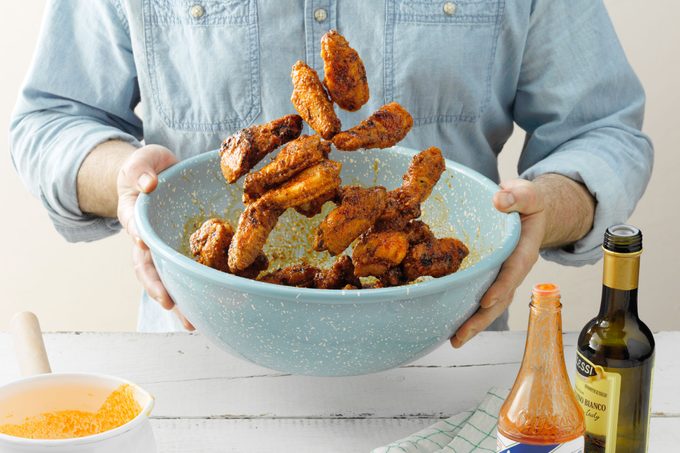 chicken wings in large bowl tossed in sauce