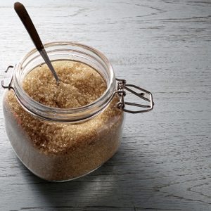 Brown sugar in glass jar on wooden table