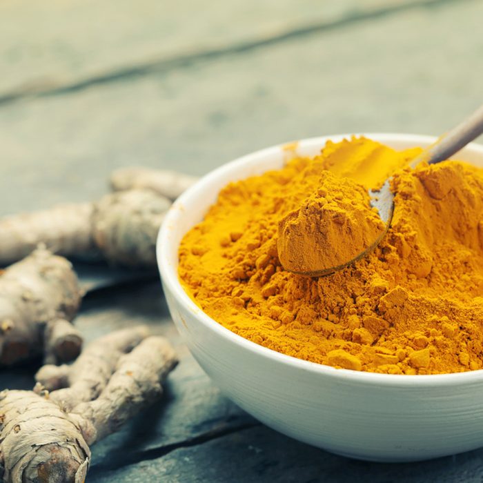Turmeric powder and turmeric on wooden background - vintage effect style.; Shutterstock ID 407533114