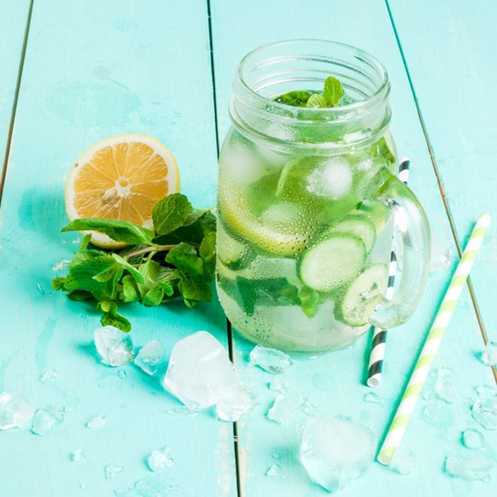 Refreshing summer drink - detox cocktail of mint, cucumber and lemon. On a light blue wooden table, bright sunlight, copy space