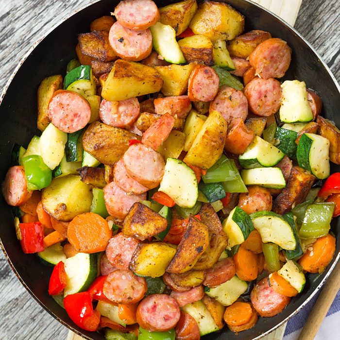 Freshly cooked one pot sausage and vegetables served in frying pan.