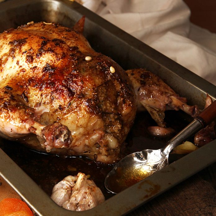 Roasted small turkey for celebration Thanksgiving day in roasting pan on old rustic wooden table. Stuffed with couscous with a fig, prunes, dried apricots, almonds and pine nuts; Shutterstock ID 492657466