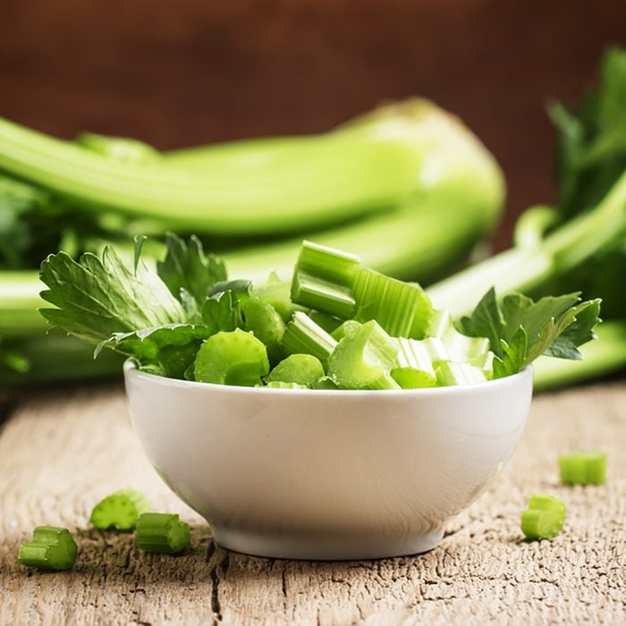 Fresh sliced celery in a white bowl on a vintage wooden background, selective focus; Shutterstock ID 517598806