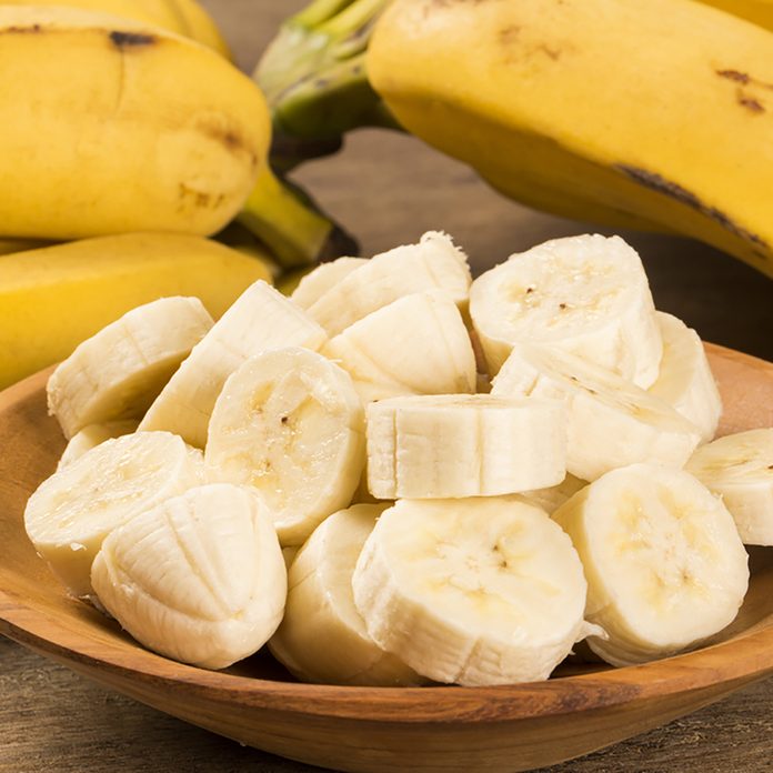 A banch of bananas and a sliced banana in a pot over a table.; Shutterstock ID 244685272; Job (TFH, TOH, RD, BNB, CWM, CM): Taste of Home