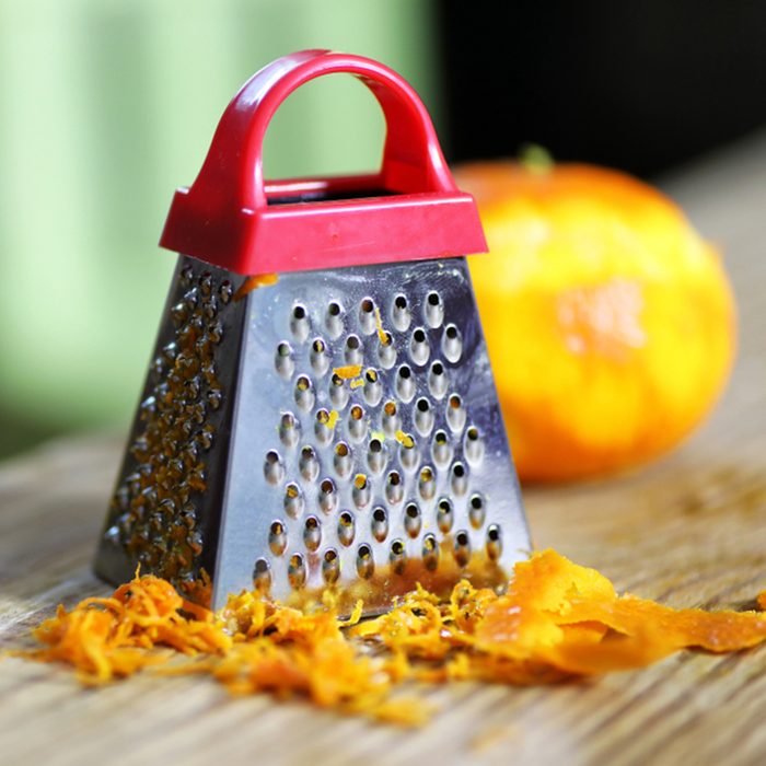 grater zest of citrus fruit and on the wooden table