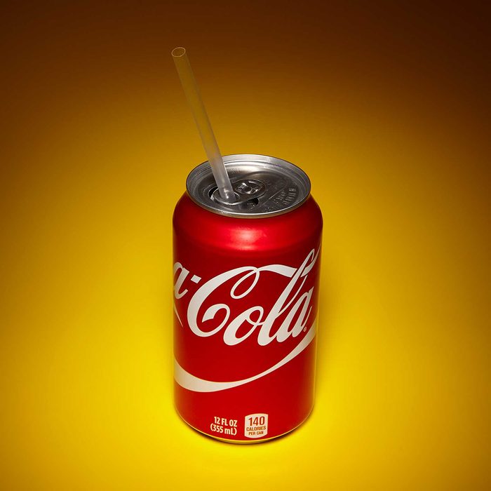 Soda can with straw held in place by the tab