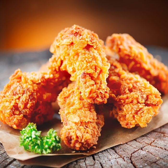 Fried chicken wings on wooden table. Breaded Crispy fried kentucky chicken tasty dinner; Shutterstock ID 608977844