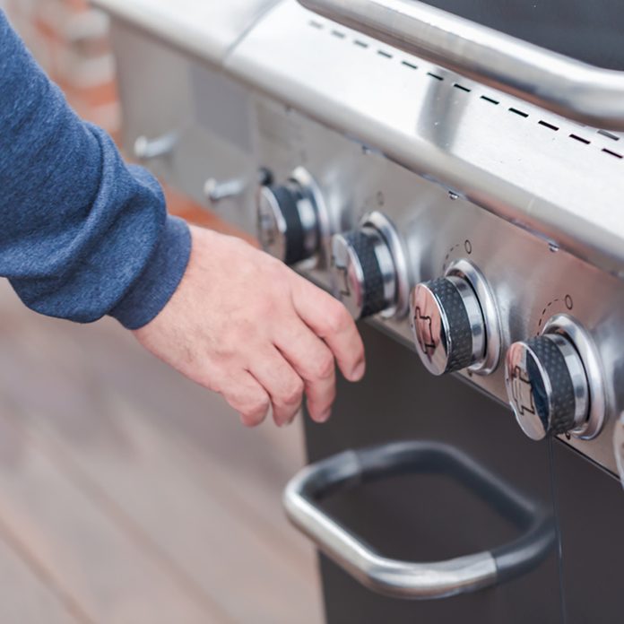 grilling safety Cooking classic burgers on outdoor gas grill in the Summer.