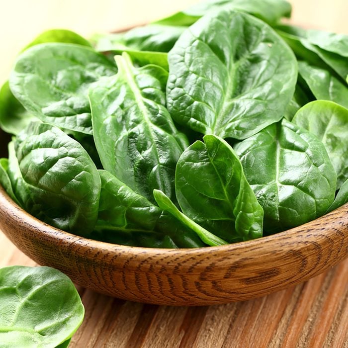 Young spinach in a wooden plate