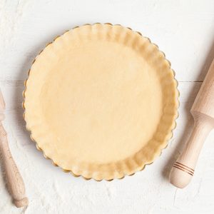 Homemade tart pie preparation, dough with yeast and rolling pin on white rustic kitchen table