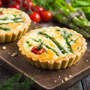 tart with asparagus and cherry tomatoes on rustic background