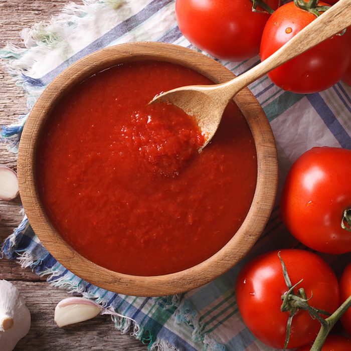 tomato sauce with garlic and basil in a wooden bowl closeup. horizontal view from above
