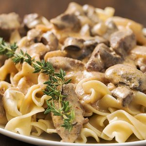 Selective focus was used on this close-up image of creamy beef stroganoff made with egg noodles, beef, mushrooms and garnished with fresh rosemary