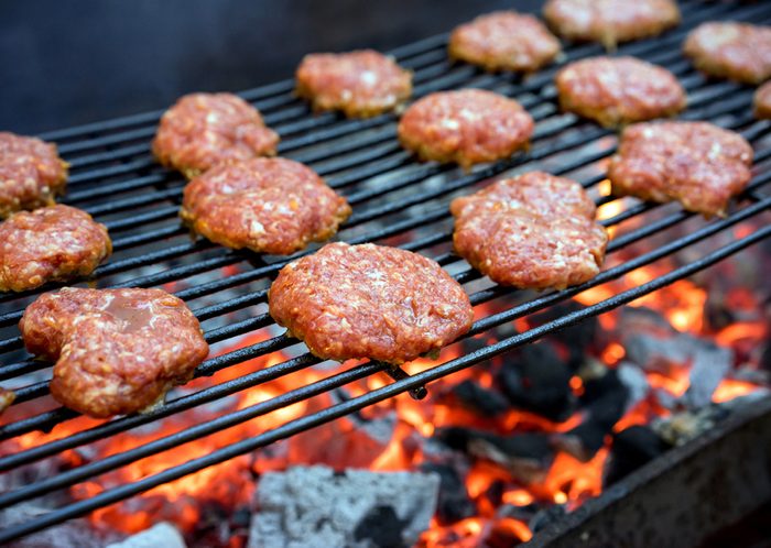 Grilled burgers on a barbecue grill close-up.