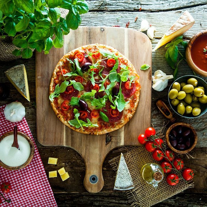 Fresh italian pizza on wood. Pizza with cheese, salami and tomatoes. Fast food. Rustic pizza