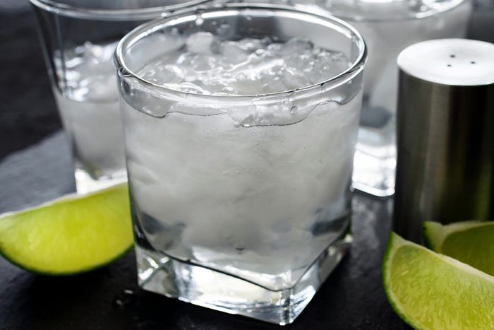 Gin and tonic with ice and lime on a dark background close up