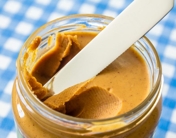 peanut butter in a jar on a knife
