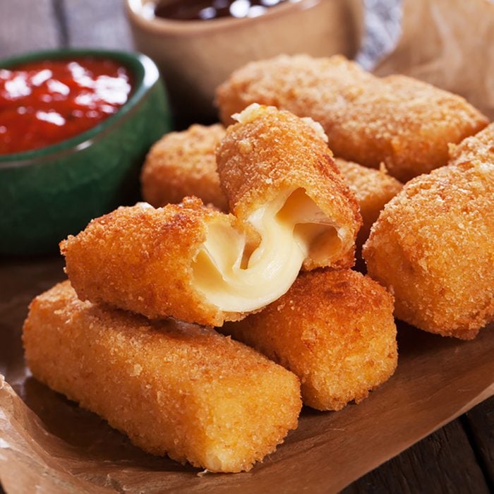 Breaded mozzarella cheese sticks with ketchup and bbq sauce