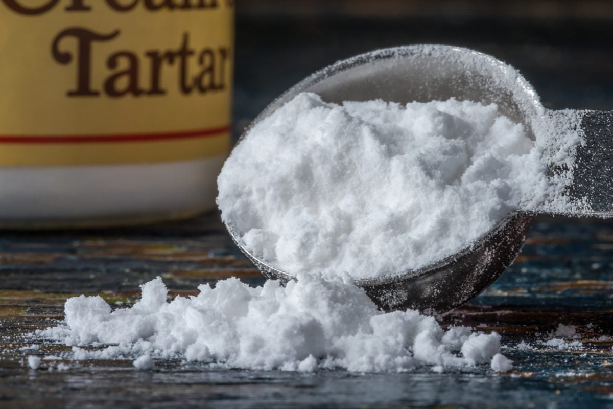 Cream of Tartar spilling from a measuring spoon.