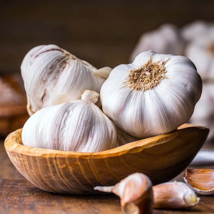 Garlic Cloves and Bulb in vintage wooden bowl.