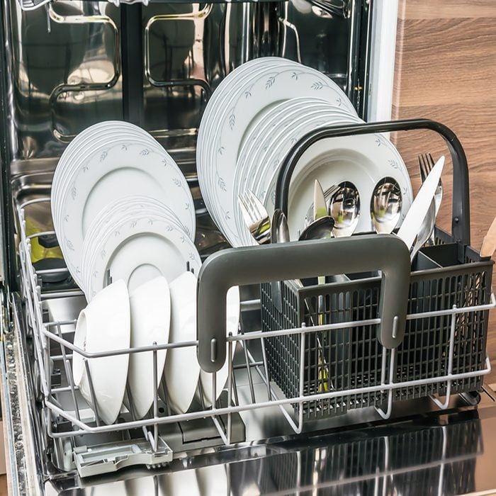 Open dishwasher with clean dishes after cleaning process.