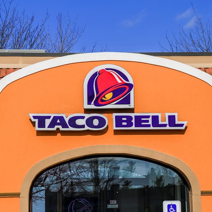  Exterior of Taco Bell fast-food restaurant with sign and logo.