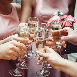 People hold in hands glasses with white wine. wedding party. friends toasting with a champagne
