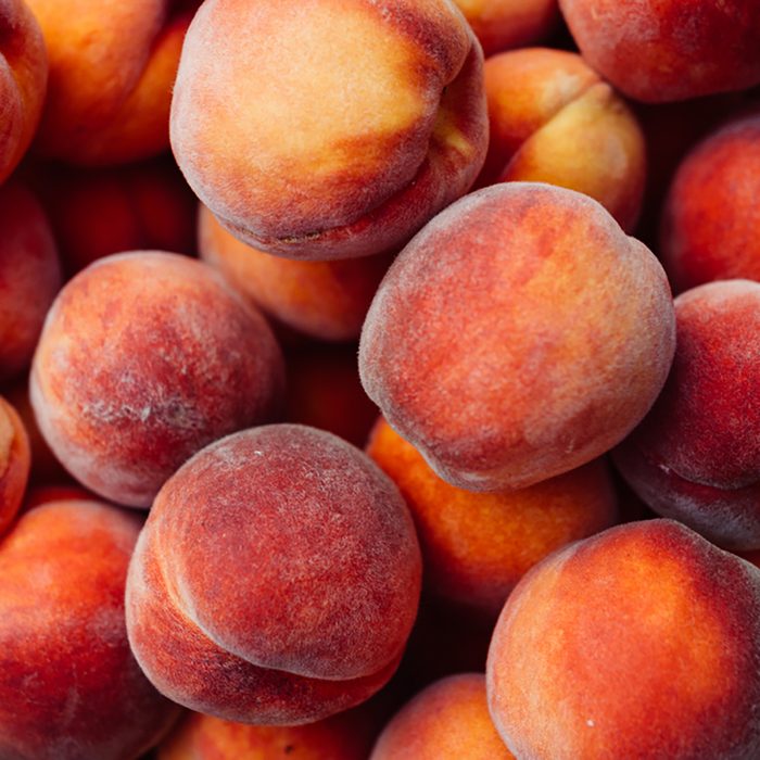 A group of ripe peaches in a bowl