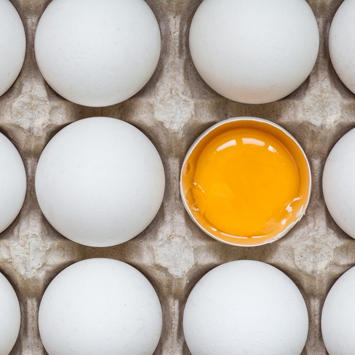 Chicken egg is half broken among other eggs