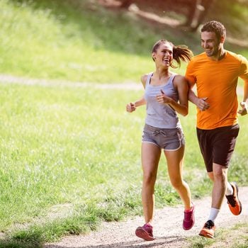 Couple jogging and running outdoors in nature; Shutterstock ID 527013196