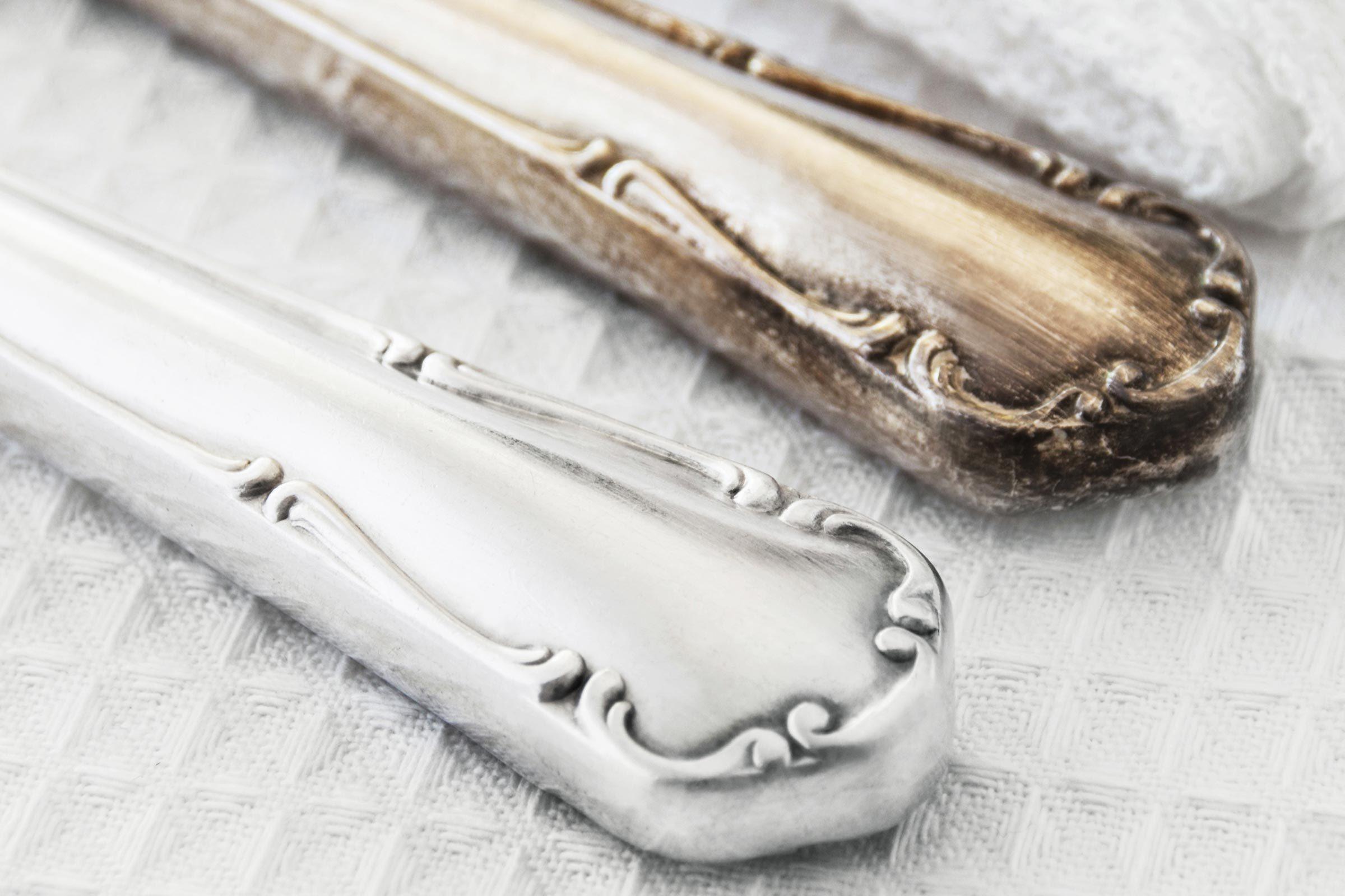 before and after of a tarnished piece of silverware on a white towel