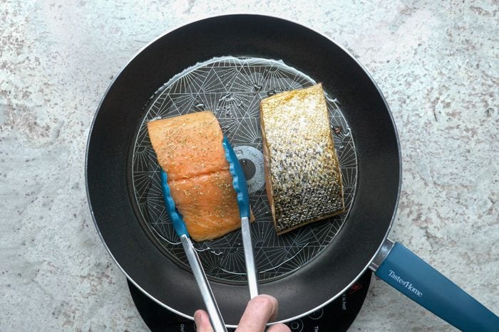 Cooking salmon fillets in a skillet