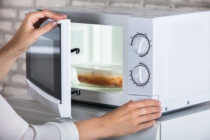 Woman's Hands Closing Microwave Oven Door And Preparing Food At Home; Shutterstock ID 694624951; Job (TFH, TOH, RD, BNB, CWM, CM): TOH How To Microwave