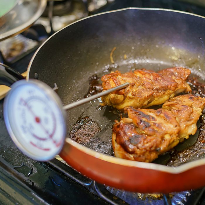 Checking the temperature with thermometer of fry chicken at home