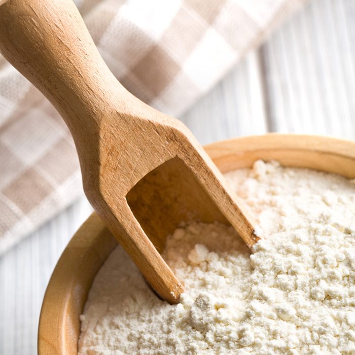 flour in wooden bowl on kitchen table; Shutterstock ID 127973471