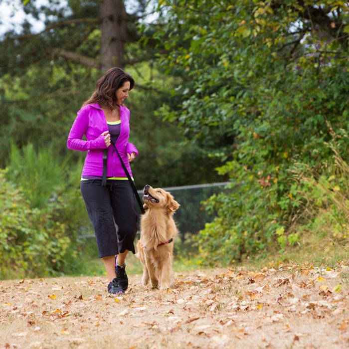 A pretty woman walking her dog