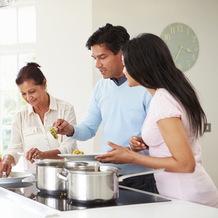 Multi Generation Indian Family Cooking Meal At Home