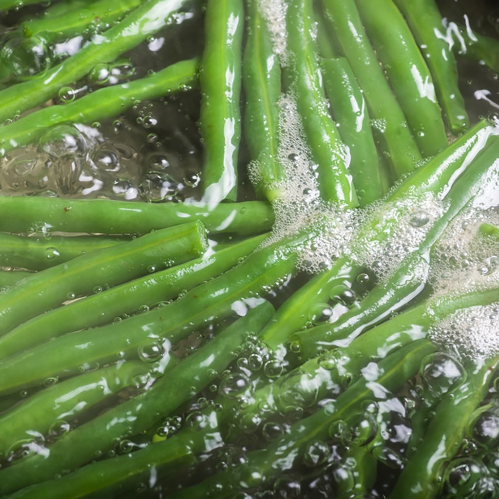 Fresh green beans boiling in water on stove